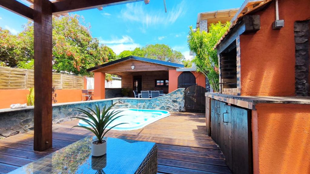 um deque exterior com uma piscina e uma casa em LA KAZ VANILLE em Bras-Panon
