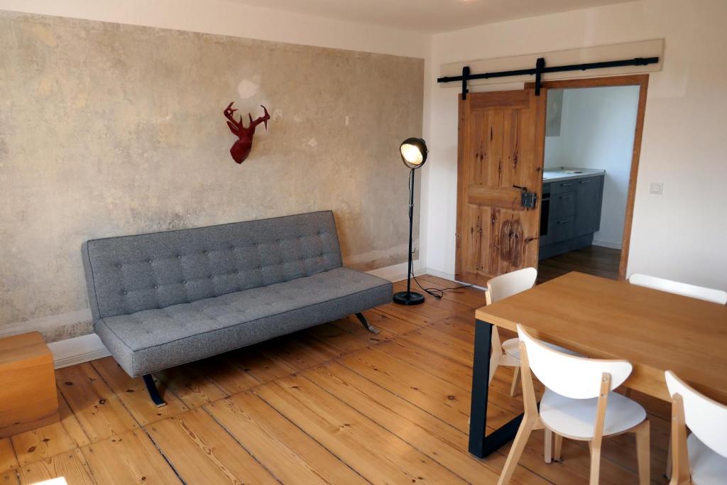 a living room with a couch and a table and a lamp at Roter Hirsch in Oderberg