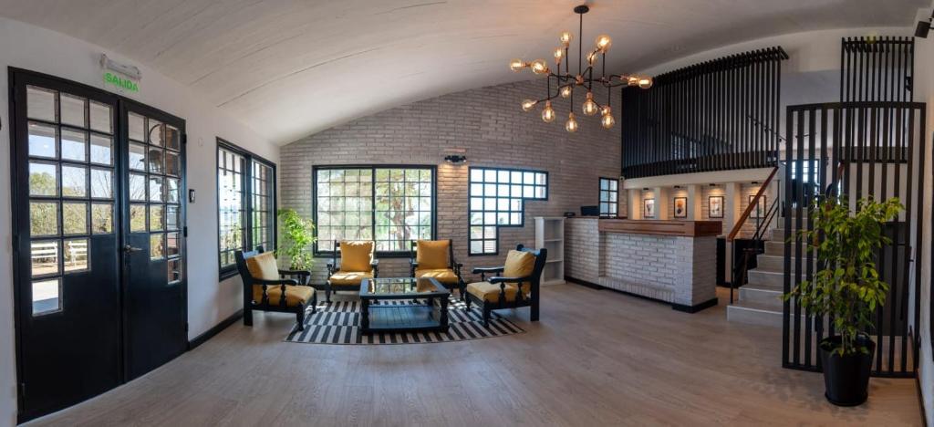 a lobby with chairs and a table and a staircase at Hotel La Colina del Sol in Villa Carlos Paz