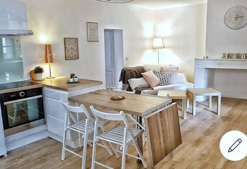 uma cozinha e sala de estar com mesa e cadeiras em L'escale Cocooning Appartement T2 Centre 3 Étoiles em Bagnères-de-Bigorre