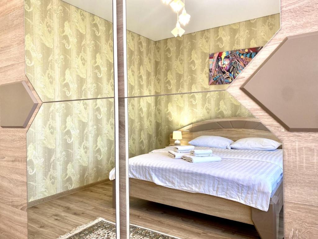 - une petite chambre avec un lit et un mur en verre dans l'établissement ApartPoltava НОВИЙ будинок, в самому ЦЕНТРІ 2-ОКРЕМІ кімнати, ПАНОРАМНИЙ БАЛКОН, à Poltava