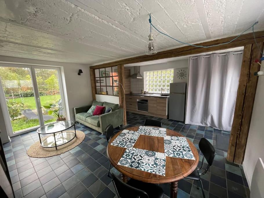 sala de estar con mesa y cocina en Petite maison de charme, en Dinsheim