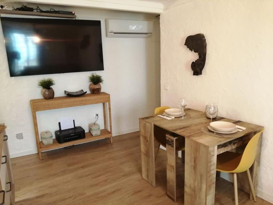 a living room with a table and a flat screen tv at appartement cosy situé à 2mn de la plage à pied climatise in Villefranche-sur-Mer