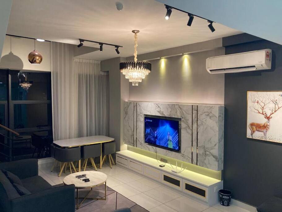 uma sala de estar com uma televisão na parede em ARTE Loft 2 Bedrooms & 3 Bathrooms 6 Pax KLCC View, High Floor & PREMIUM em Kuala Lumpur