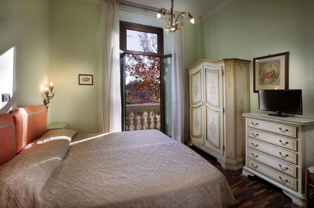 a bedroom with a bed and a dresser and a window at Hotel Savona in Montecatini Terme