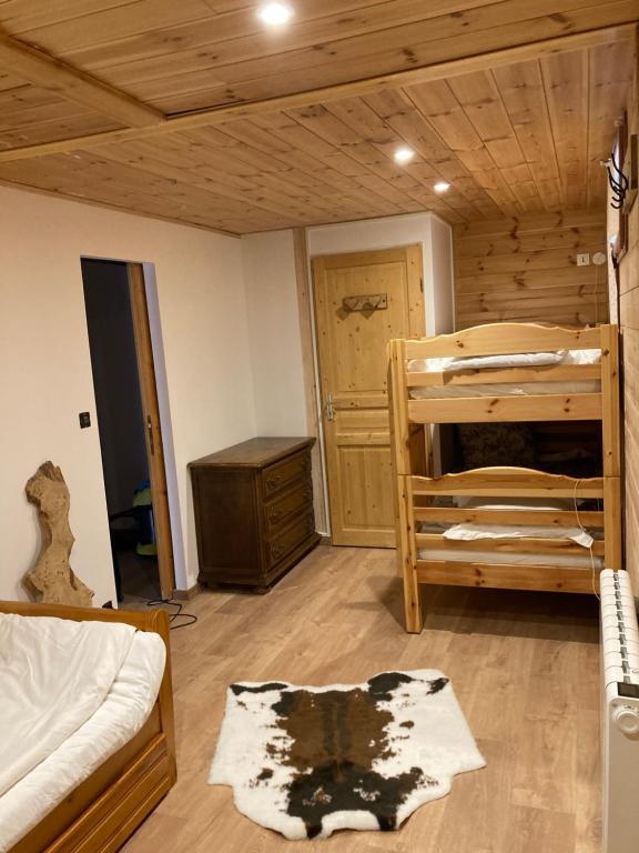 a room with two bunk beds and a wooden ceiling at Le Chalet d’Andrea in Vars