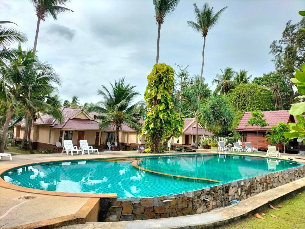 a swimming pool at a resort with palm trees at Salatan Resort in Ko Lanta