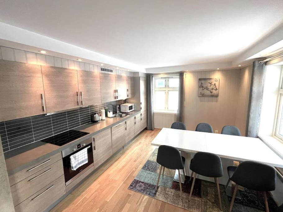 a large kitchen with a table and some chairs at Skjomtind - Modern apartment with free parking in Narvik
