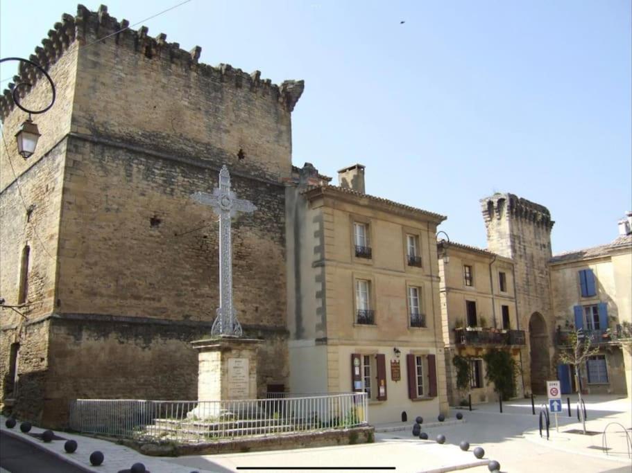 una iglesia con una cruz frente a un edificio en Chez Lydia - Osez la vie de chateau ! Pont du Gard, Uzès en Remoulins