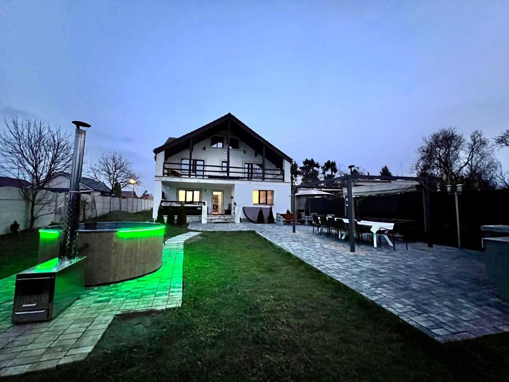 ein Haus mit grünem Leuchten im Hof in der Unterkunft Garden Villa in Braşov