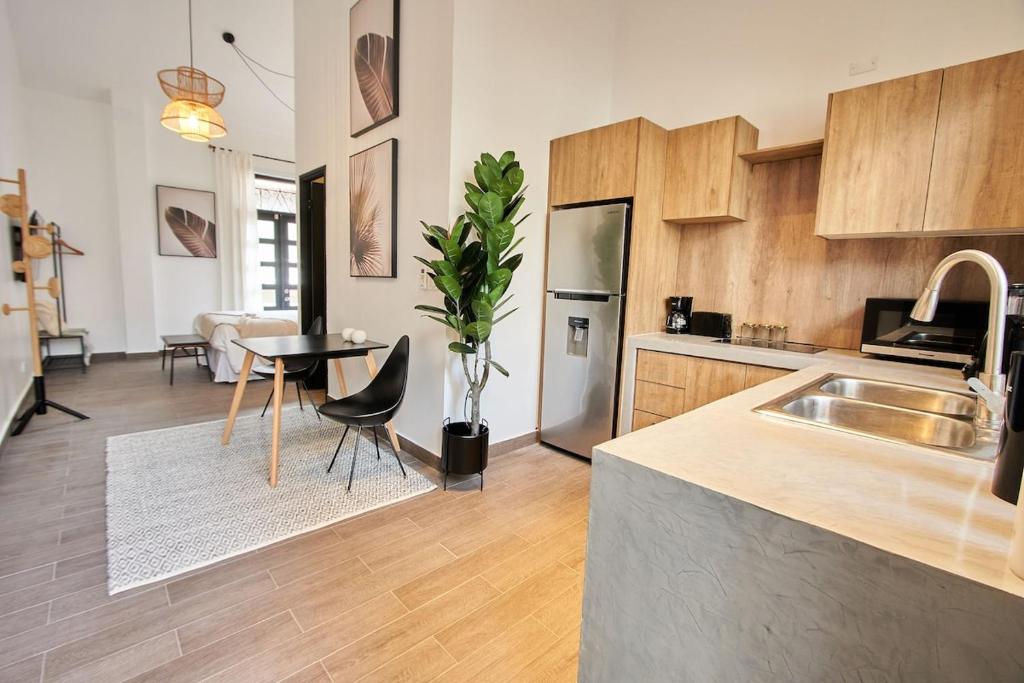 a kitchen with a sink and a table in a room at AmazINN Places Rooftop and Design Pool III in Panama City