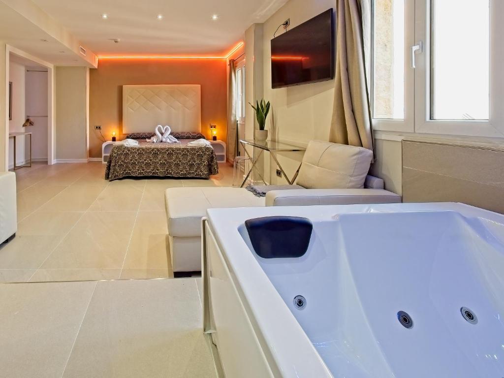 a living room with a bath tub and a bedroom at Caballero Errante in Madrid