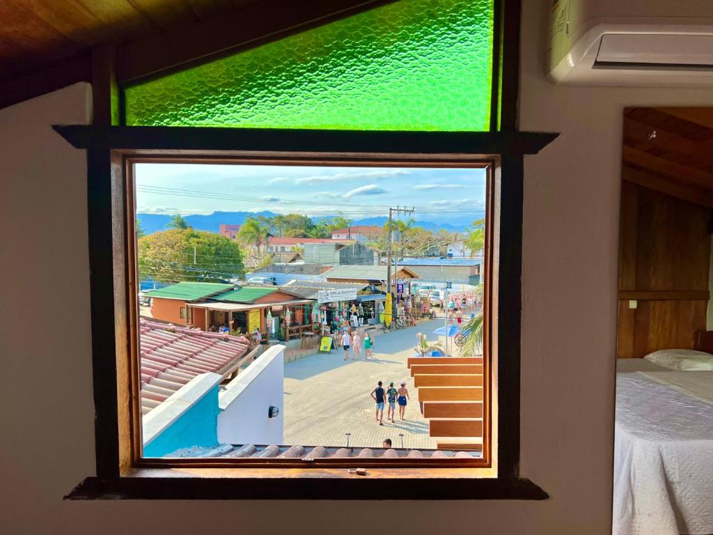 a window in a room with a view of a town at Casa Rio - 04 Quartos de Frente para o Mar in Guarda do Embaú