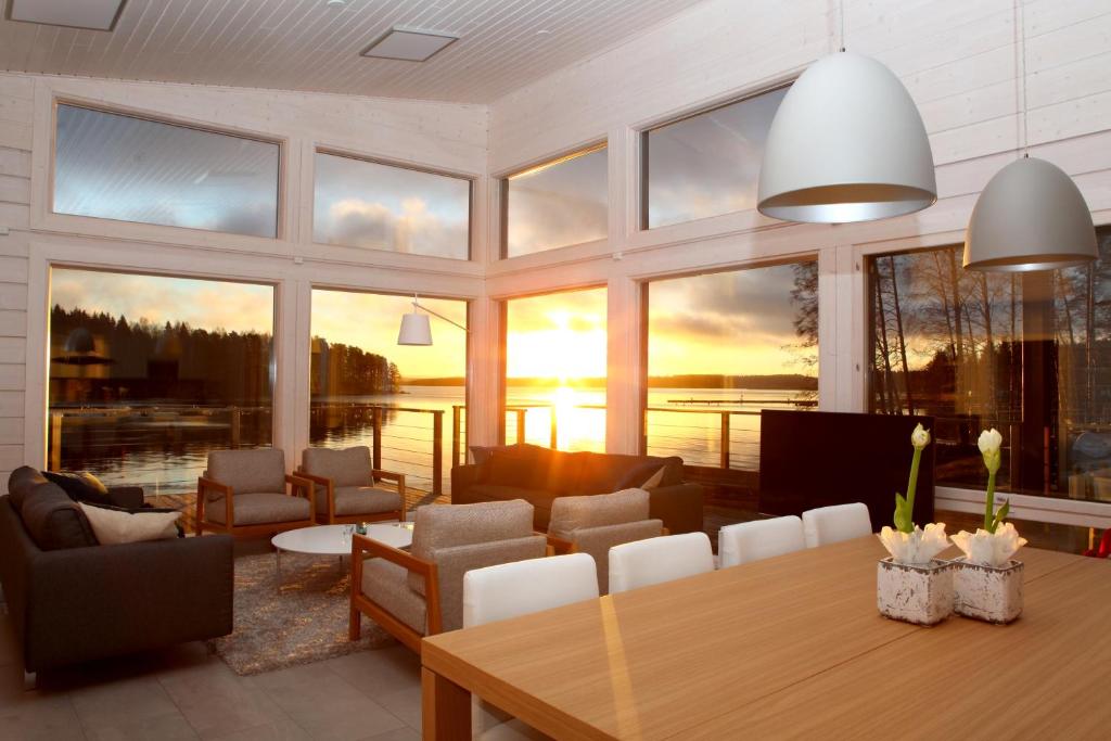 uma grande sala de estar com mesa e cadeiras em Villa Jolla em Padasjoki