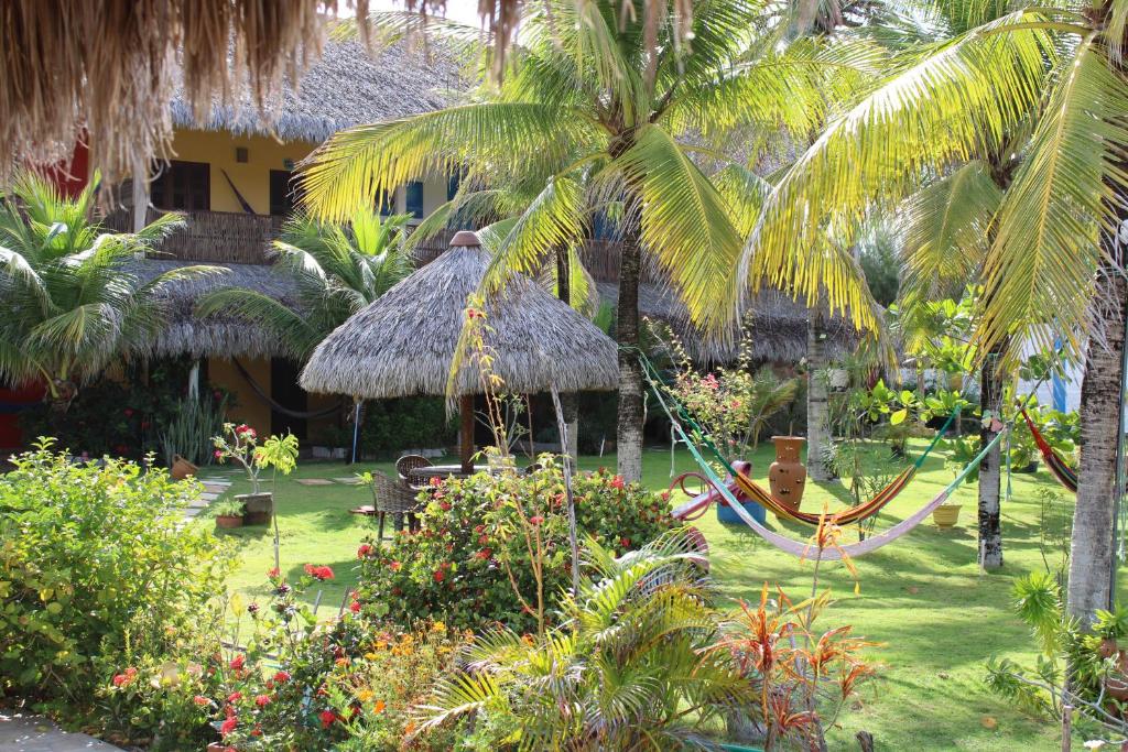 a resort with a hammock in a yard with palm trees at A Toca do Bem-Te-Vi in Águas Belas