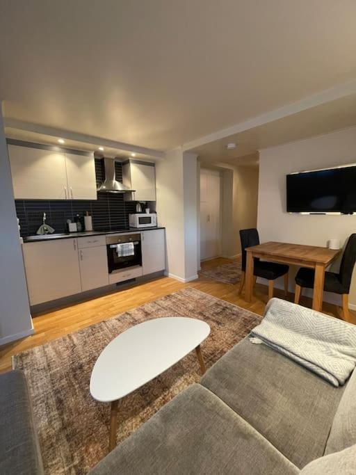 een woonkamer met een bank en een tafel bij Revtind - Modern apartment with free parking in Narvik