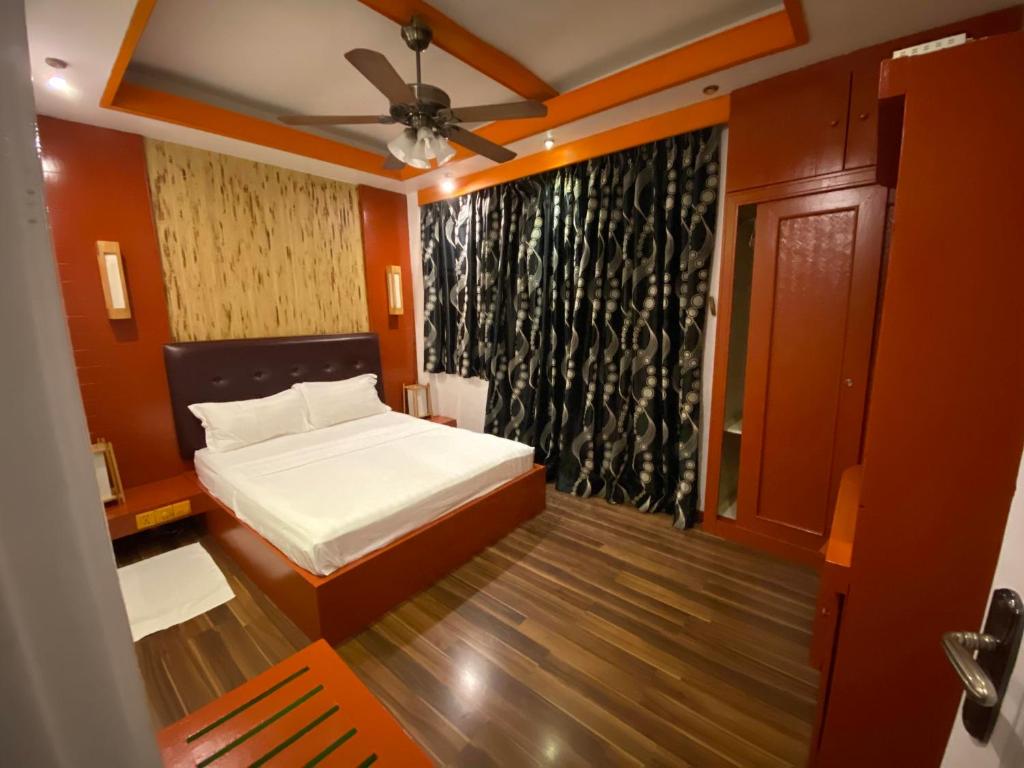 a bedroom with a white bed and a black curtain at Niu Inn & Spa in Hulhumale