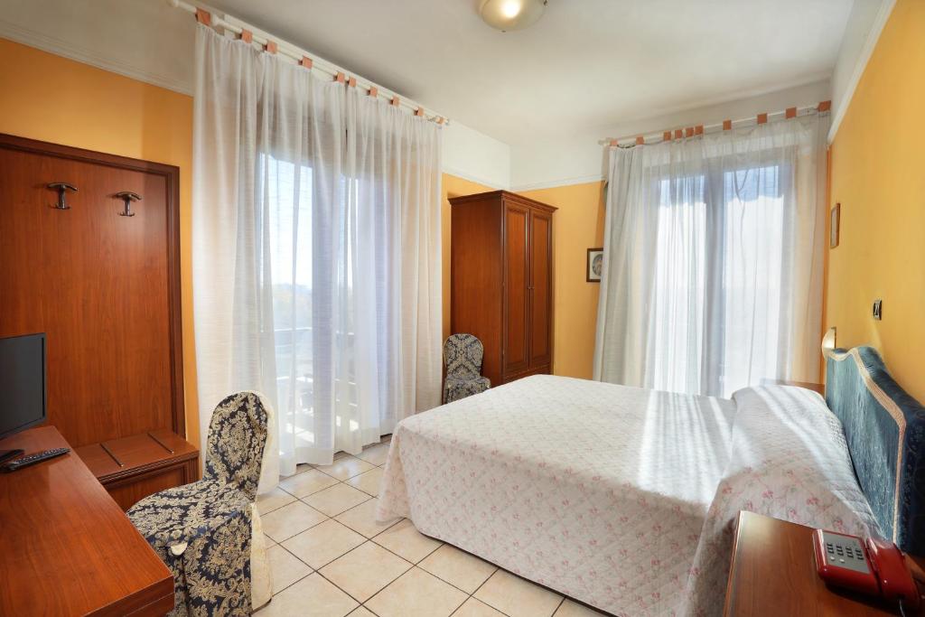 モンテカティーニ・テルメにあるHotel Salusのベッドルーム1室(ベッド1台、デスク、窓付)