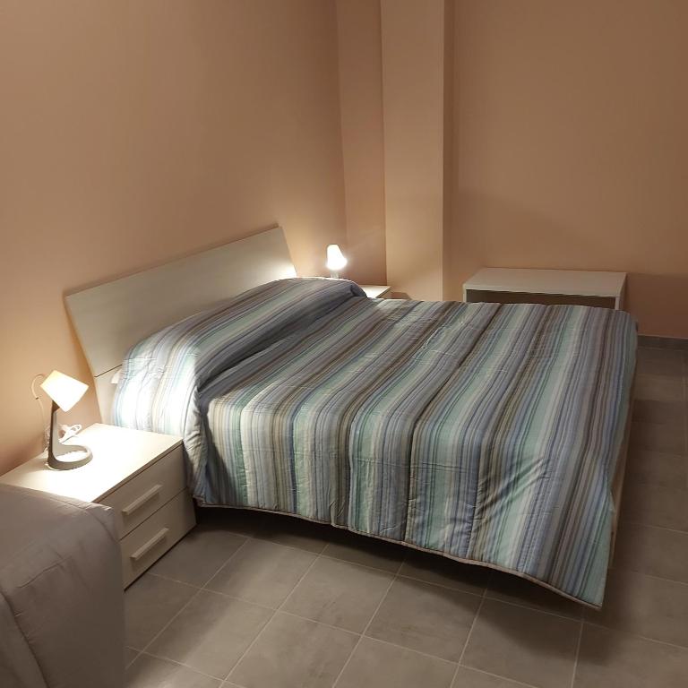 a bedroom with a bed with a striped bedspread at FARE BnB - Room & Breakfast Santa Maria in Reggio Emilia