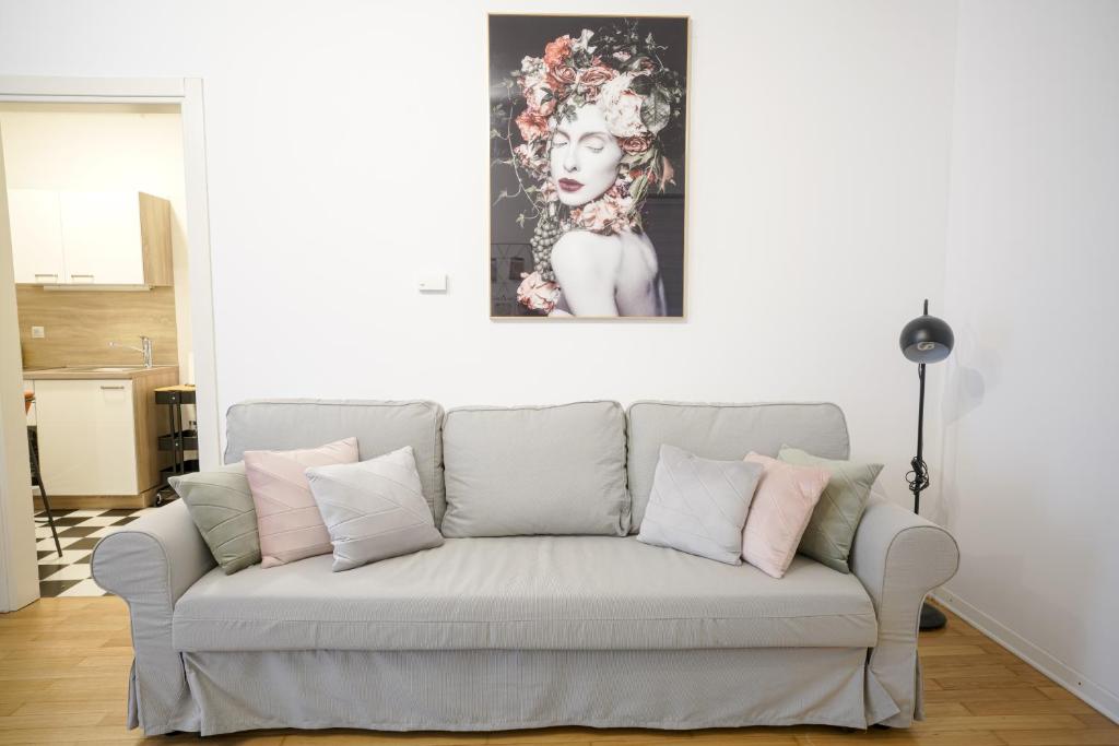 um sofá numa sala de estar com um quadro na parede em APARTIQUE ZAGREB studio apartman em Zagreb