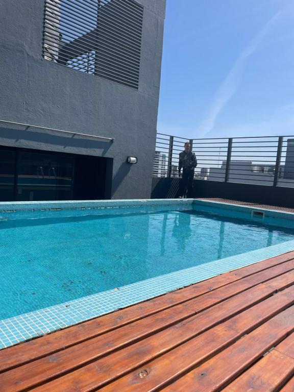 un homme debout à côté d'une piscine dans un bâtiment dans l'établissement terraza de nicaragua, à Buenos Aires