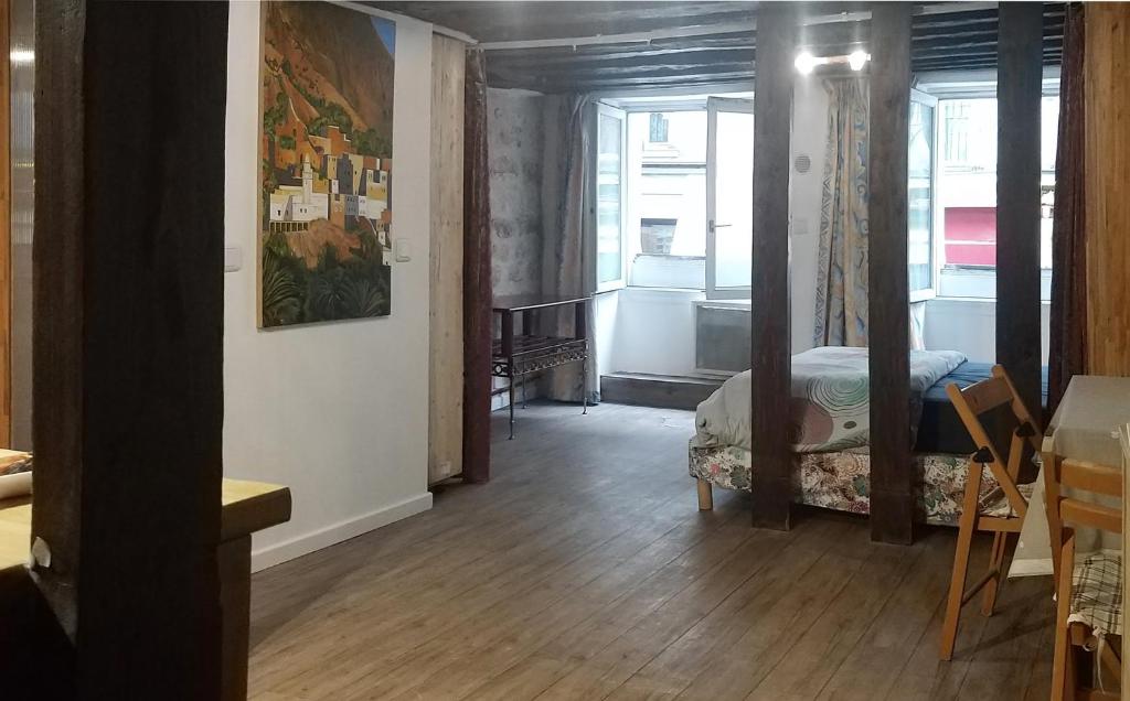ein Zimmer mit einem Schlafzimmer mit einem Bett und einem Fenster in der Unterkunft HAUSSMANN ESPACE in Paris