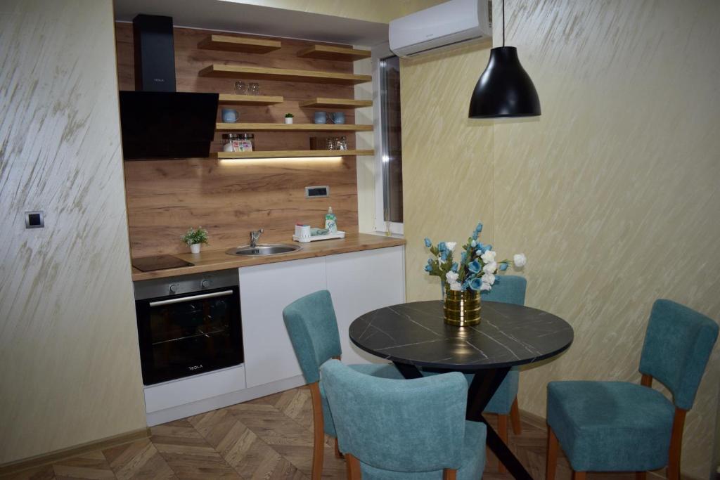 - une cuisine avec une table, des chaises et un évier dans l'établissement Pink House Apartments, à Jagodina