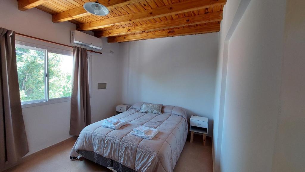 Habitación pequeña con cama y ventana en Los Coirones en Maipú