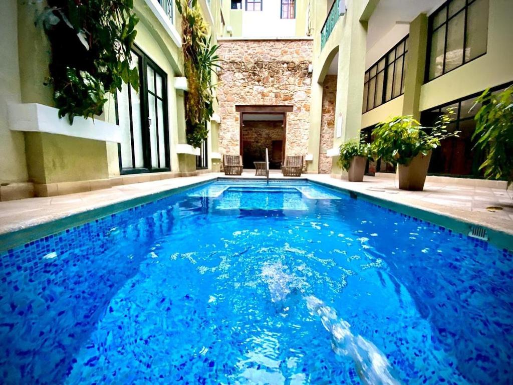 a large blue swimming pool in a building at AmazINN Places Casco Viejo unique Desing and Pool II in Panama City