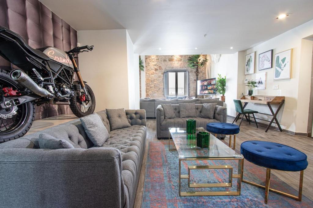 un salon avec un canapé et une moto au mur dans l'établissement AmazINN Places Casco Viejo Penthouse Rooftop and Pool, à Panama City