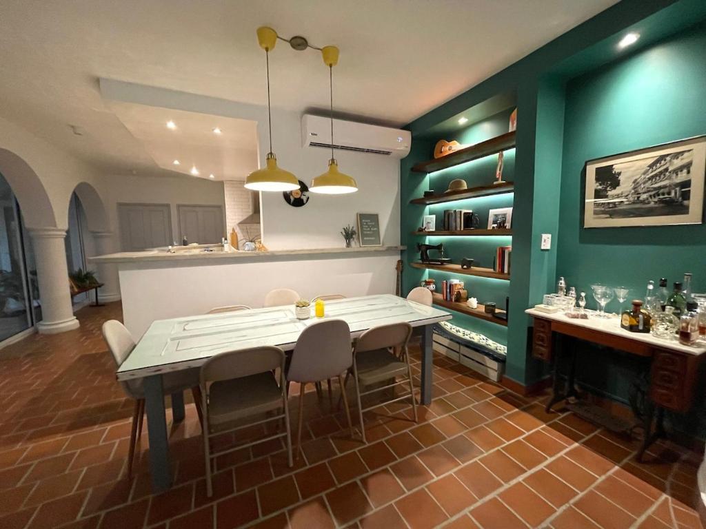 a kitchen with a table and chairs and green walls at AmazINN Places Casco Viejo Casa Espanola in Panama City