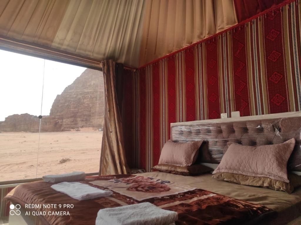 a bedroom with a bed with a view of the desert at Star Wars Wadi Rum in Wadi Rum