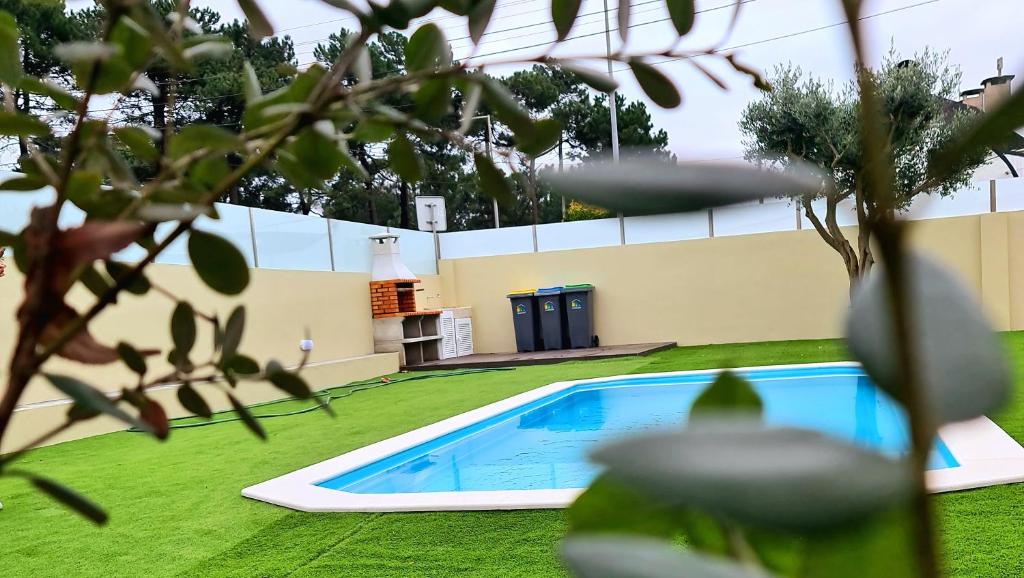- une piscine dans une cour avec de l'herbe verte dans l'établissement VILLAS com piscina, à Vila Nova de Gaia