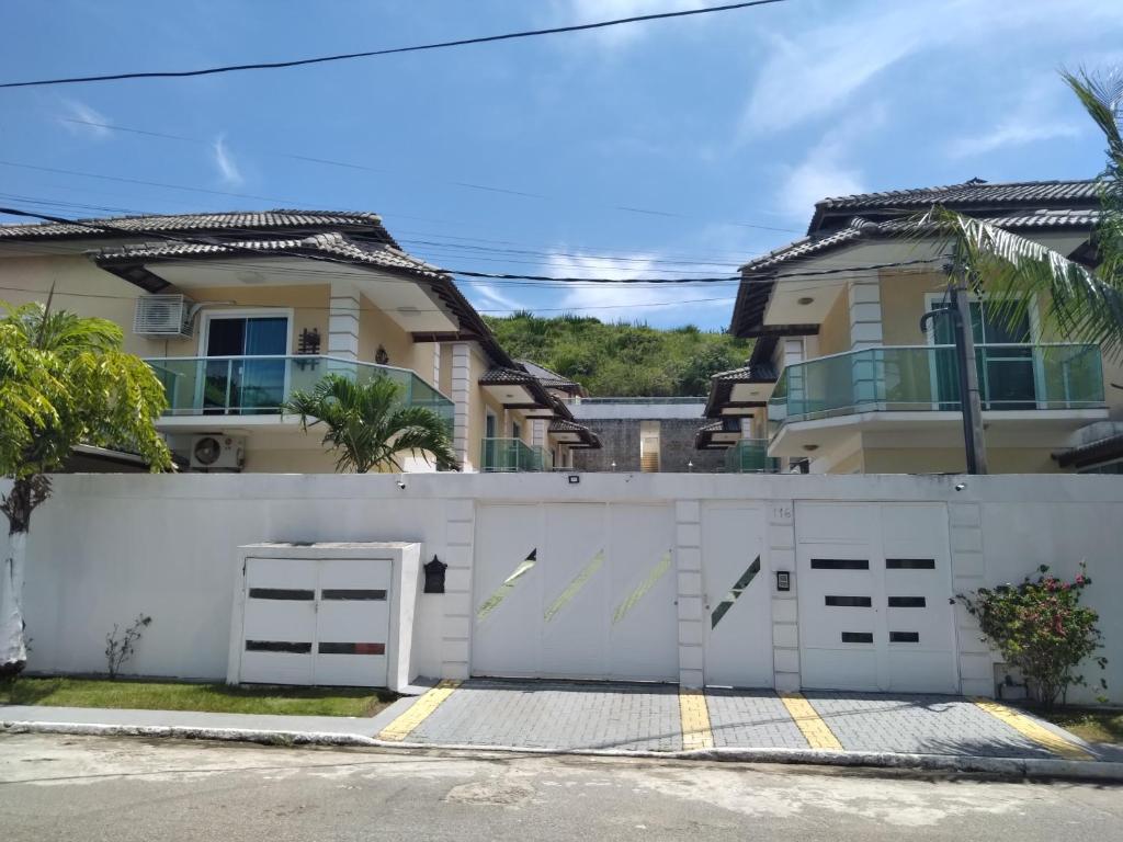 una cerca blanca frente a una casa en DIAS INESQUECÍVEIS NO PERÓ, en Cabo Frío