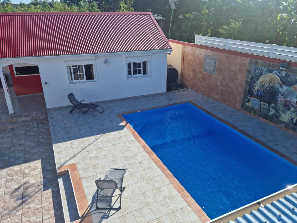 a swimming pool in a backyard with a house at Charmant T2 à 10 minutes de la plage du Souffleur in Petit-Canal
