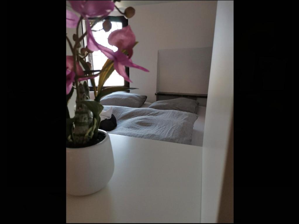 a bedroom with a bed and a vase with a flower at Unique studios near Tivoli in Ljubljana