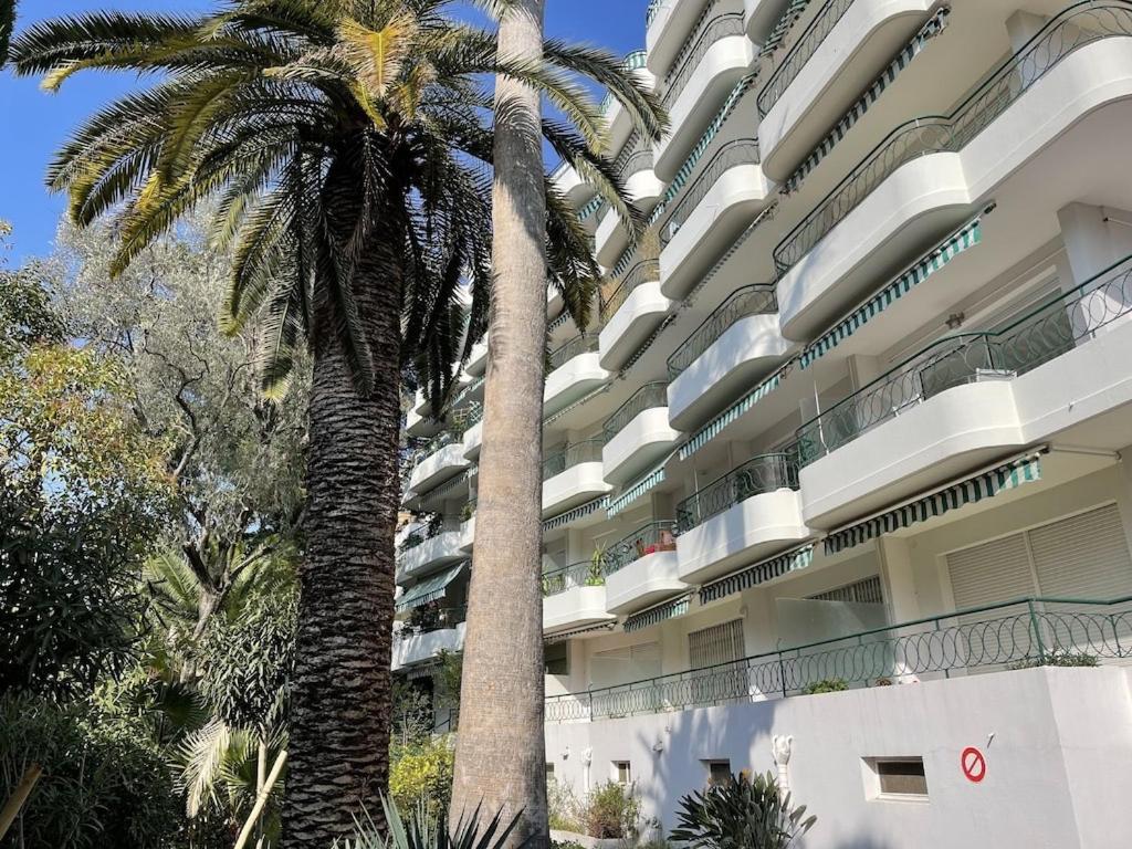 un grande edificio con palme di fronte di Cannes 100 mètres de la plage a Cannes