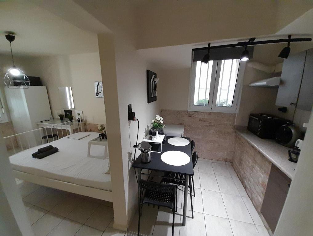 a room with a bed and a table and a bathroom at Cocomelo Apts in Heraklio Town