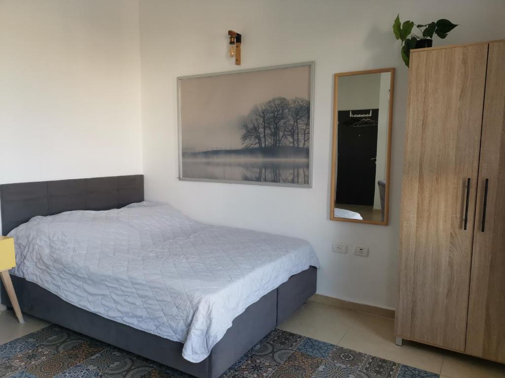 1 dormitorio con 1 cama y una foto en la pared en נופש מול הכנרת Vacation in front of the Sea Galilee en Tiberias