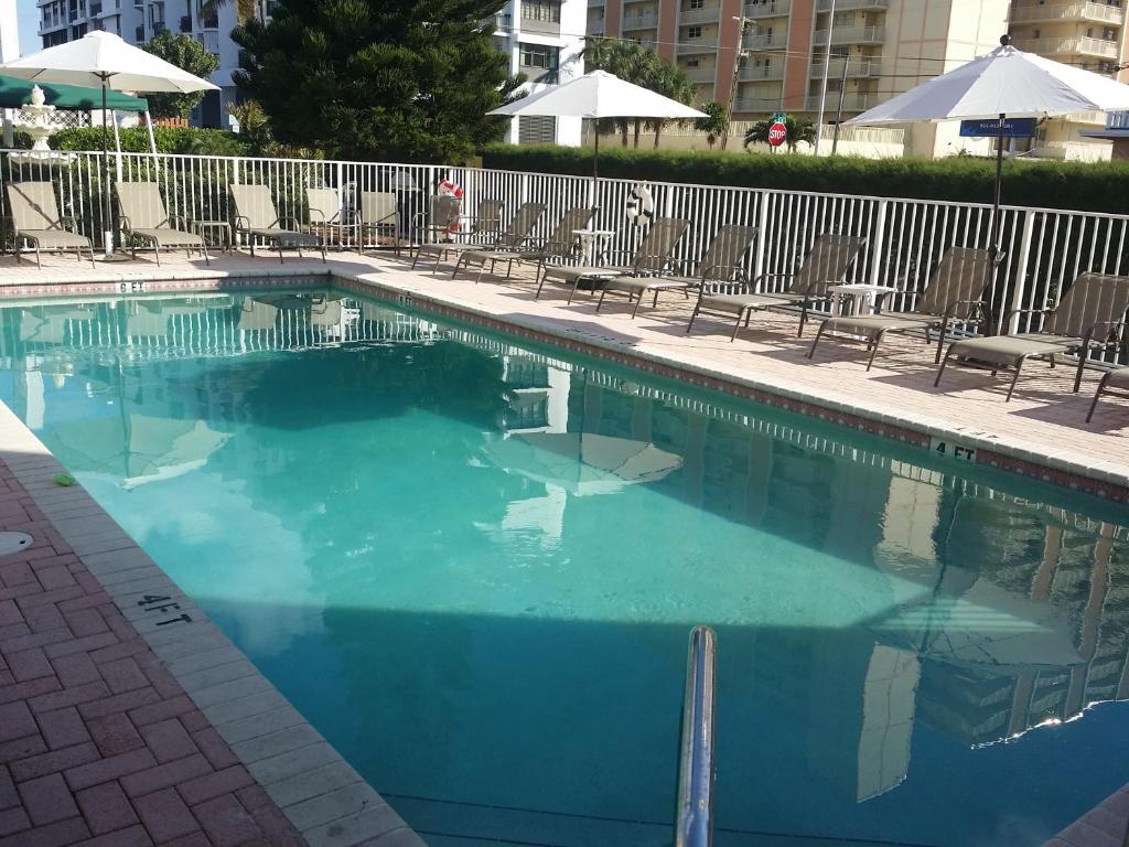 a swimming pool with blue water in a hotel at Shores Terrace in Pompano Beach