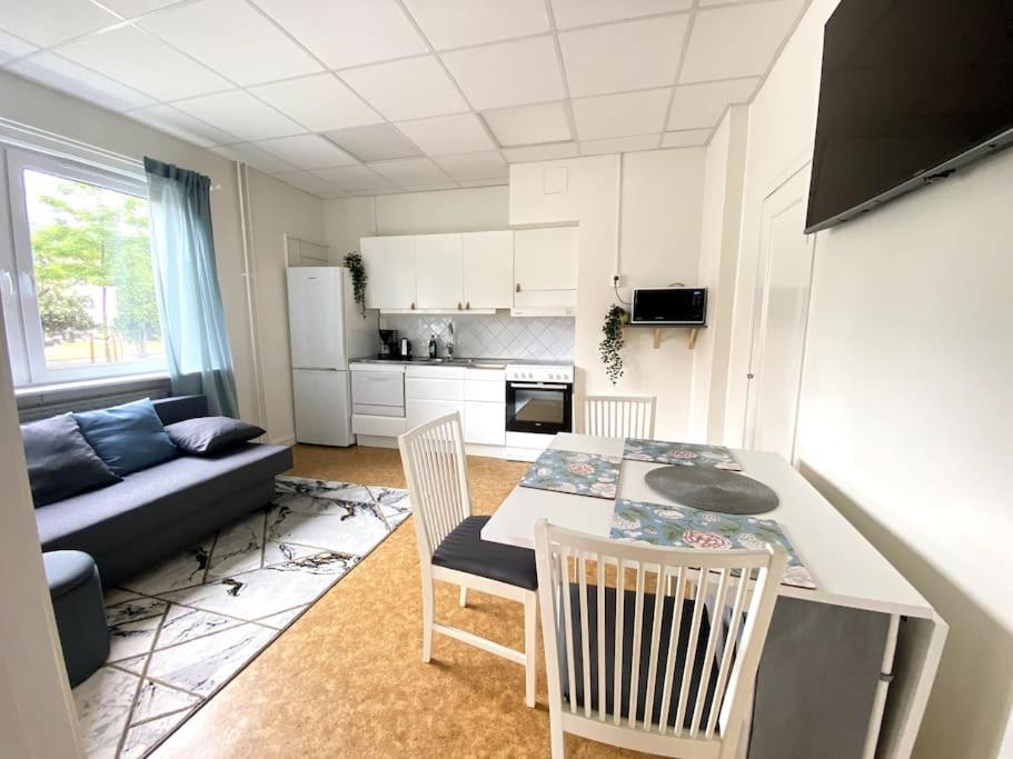 uma sala de estar com um sofá, uma mesa e cadeiras em central apartment with free parking em Huskvarna