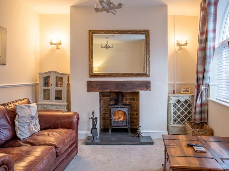 a living room with a couch and a fireplace at Charming 2 Bed House in Tewkesbury Centre in Tewkesbury