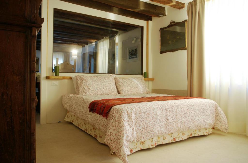 1 dormitorio con 1 cama grande y ventana grande en Appartamento Corte Bragadin, en Venecia