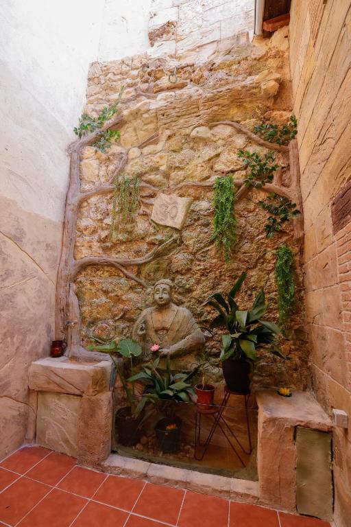 a stone wall with a statue and some plants at Casa torre del Carmen Cazorla II in Cazorla