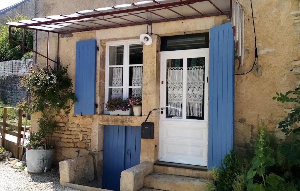 una casa con una puerta azul y blanca en Le Gîte du Lapin Bleu, en Baigneux-les-Juifs