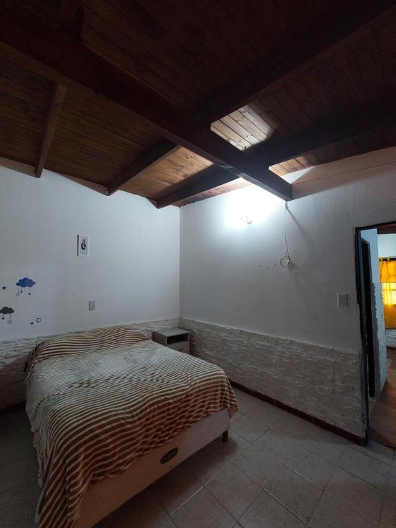 1 dormitorio con 1 cama y TV en Alquileres temporarios Anahi en Las Heras