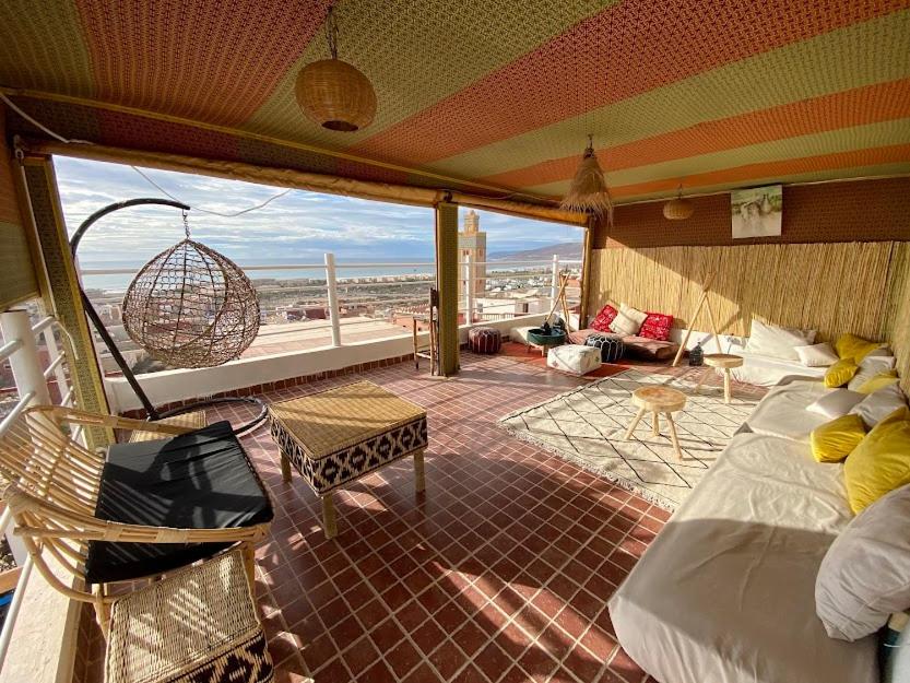 a room with a balcony with a bed and a swing at Caban Surf Tamraght in Tamraght Ouzdar