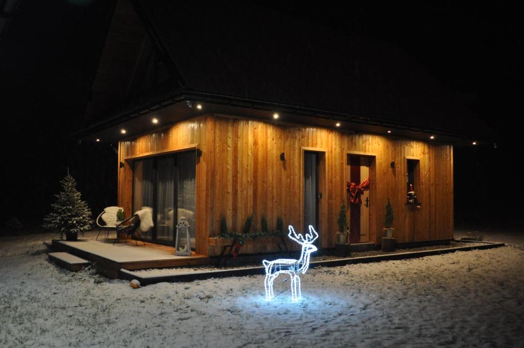 ein Haus mit einem Rentier davor in der Unterkunft Gorczańska Chatka in Osobie