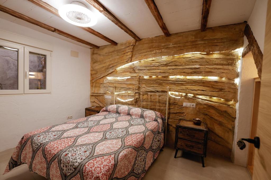 a bedroom with a bed and a stone wall at Casa torre del Carmen Cazorla II in Cazorla