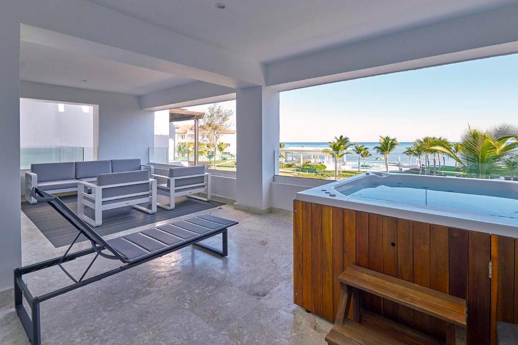 Elle comprend un salon avec un bain à remous et une terrasse. dans l'établissement Punta Palmera ocean views 1bed apartment Cap Cana, à Punta Cana